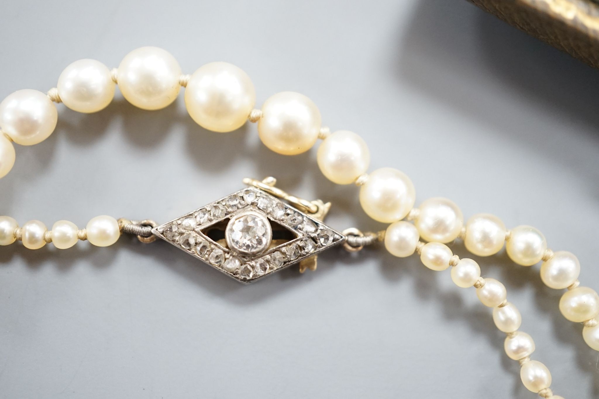 A single strand graduated seed pearl necklace, with yellow metal and diamond set clasp 42cm and a cased pair of similar Austro Hungarian ear clips.